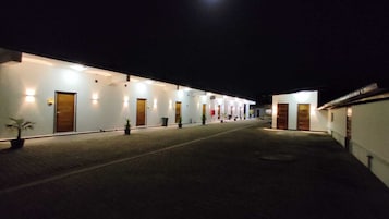 Un pasillo de hotel con varias puertas, cada una iluminada por luces en la pared.
