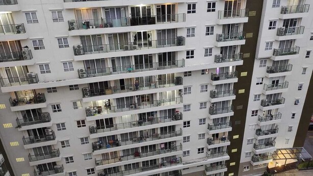 A multi-story residential building with balconies, air conditioning units, and a parking area below. - Gateway Pastuer Apartement by Clover  (Cimahi)
