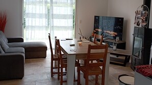Ein modernes Wohnzimmer mit Essbereich, einer Couch, einem Fernseher und einem Kamin.