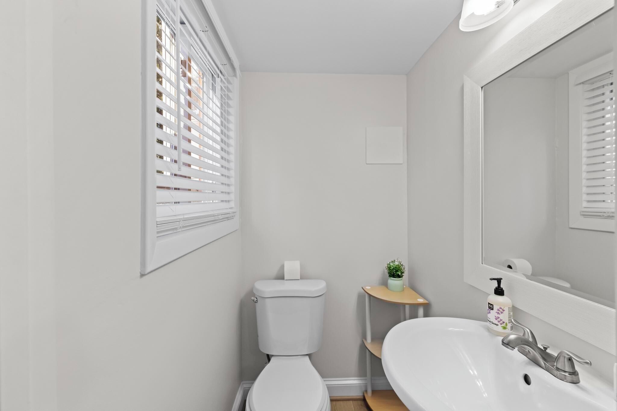 Un bagno con il water, un lavandino e uno specchio.