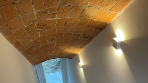 A staircase with a brick ceiling and white walls, leading to a door with a glass panel. - Spectacular views of UNESCO Castles, Langhe valley, French, Italian & Swiss alps (Costigliole di Asti)