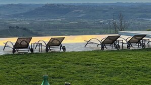 A grassy area with lounge chairs and two green glass bottles. - Spectacular views of UNESCO Castles, Langhe valley, French, Italian & Swiss alps (Costigliole di Asti)