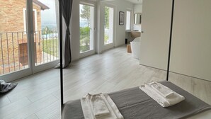 A bedroom with a large bed, a balcony, and a view of the outside. - Spectacular views of UNESCO Castles, Langhe valley, French, Italian & Swiss alps (Costigliole di Asti)