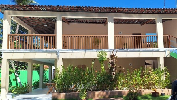 A two-story building with a covered patio and a swimming pool. - Pousada Caminho do Paraíso (Ipojuca)
