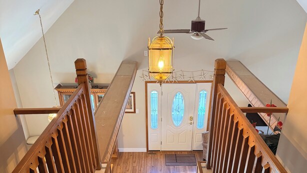 A wooden staircase with a carpeted landing, a chandelier, and a ceiling fan. - Coastal Retreat in Angola-by-the-Bay Lewes (Lewes)