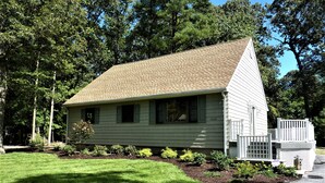A single-story house with a sloped roof, a front porch, and a well-maintained lawn. - Coastal Retreat in Angola-by-the-Bay Lewes (Lewes)