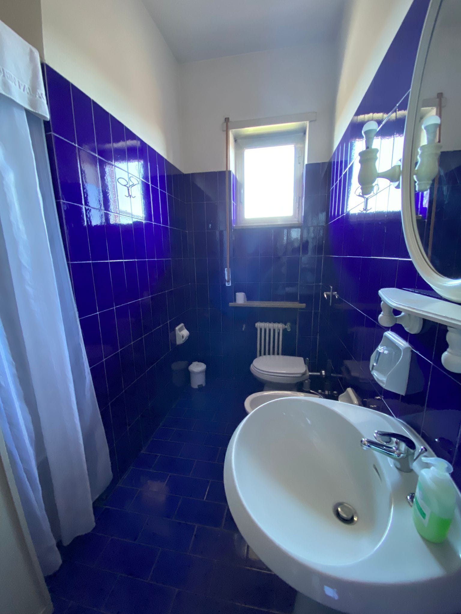 Ein Badezimmer mit Waschbecken, Spiegel und Fenster.