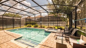 Piscina ao ar livre coberta com espreguiçadeiras e uma banheira de hidromassagem.