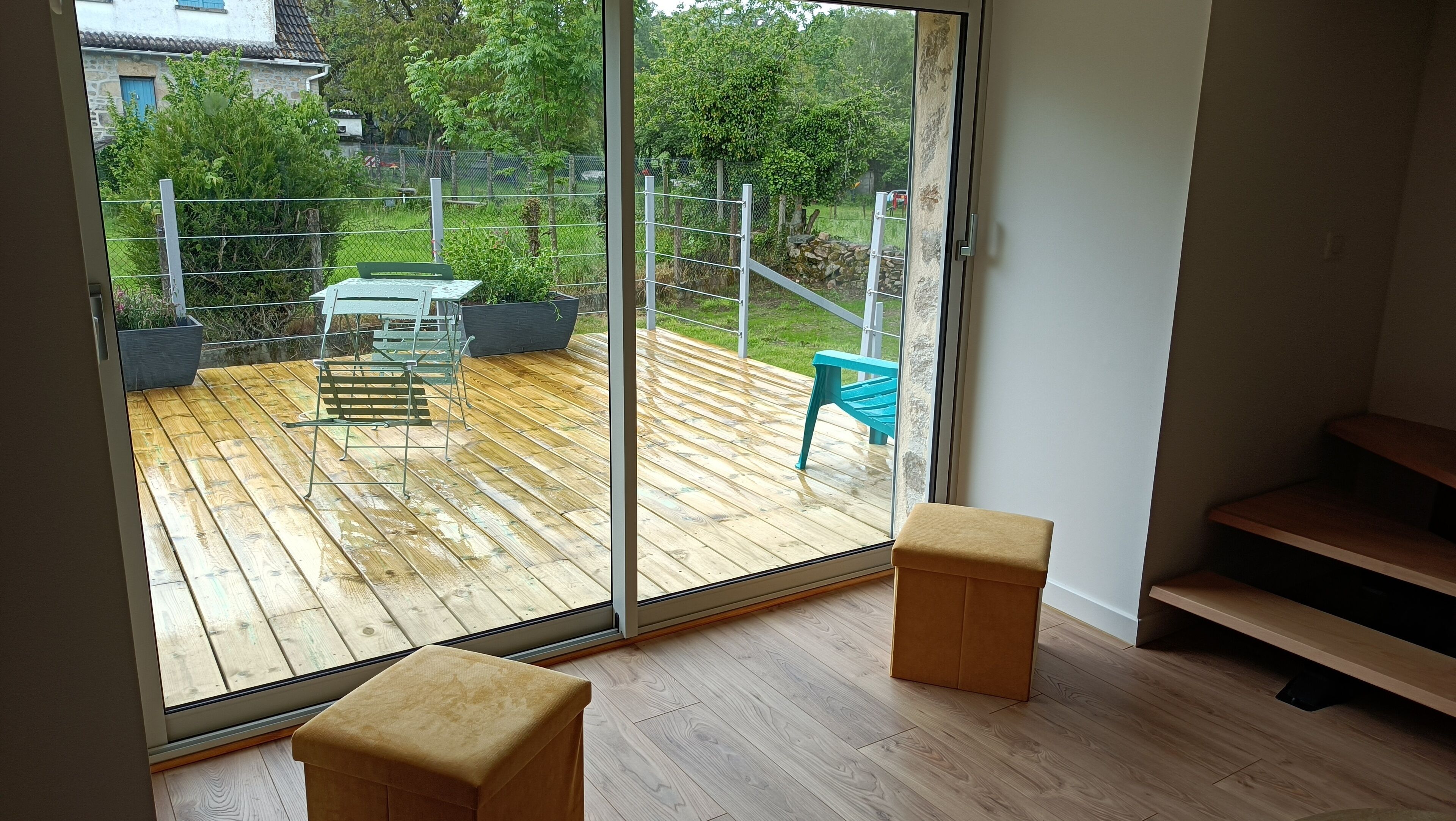 A room with a sliding glass door leading to an outdoor deck with a table and chairs.