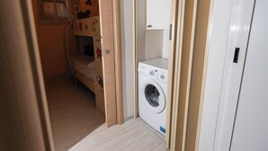 Un cuarto de lavado con lavadora y un gabinete de madera.