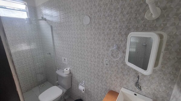 Un baño con inodoro, lavabo y espejo.