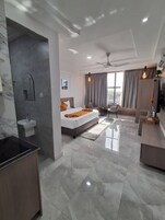 Una habitación de hotel moderna con cama, escritorio, tocador y baño.