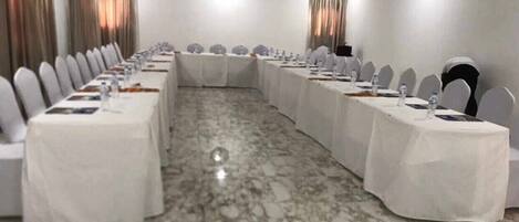 A conference room with a long table, chairs, and a clock on the wall.