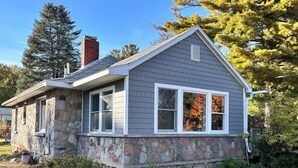 A house with a stone foundation and a grey siding exterior.