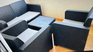 A balcony with a seating area consisting of two sofas and a small table.