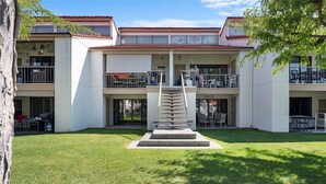 Un bâtiment à deux étages doté d’un escalier central, d’un espace extérieur aménagé pour s’asseoir et d’un patio couvert.