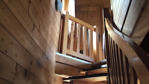 Eine Holztreppe mit Geländer, die zu einer oberen Ebene führt.
