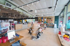 Un vaste magasin proposant une grande variété de produits, avec des comptoirs en bois, des étagères bien garnies et une vue dégagée sur l’agencement du magasin.