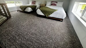 A bedroom with two beds, a window, and a staircase. - Camp Landa Resort (New Braunfels)
