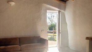 Ein geräumiges Zimmer mit Holzboden, einer Couch und einem Teppich.