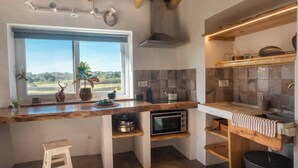 Eine Küche mit Fenster, Backofen, Holz Arbeitsplatte und einem hängenden Handtuchhalter.