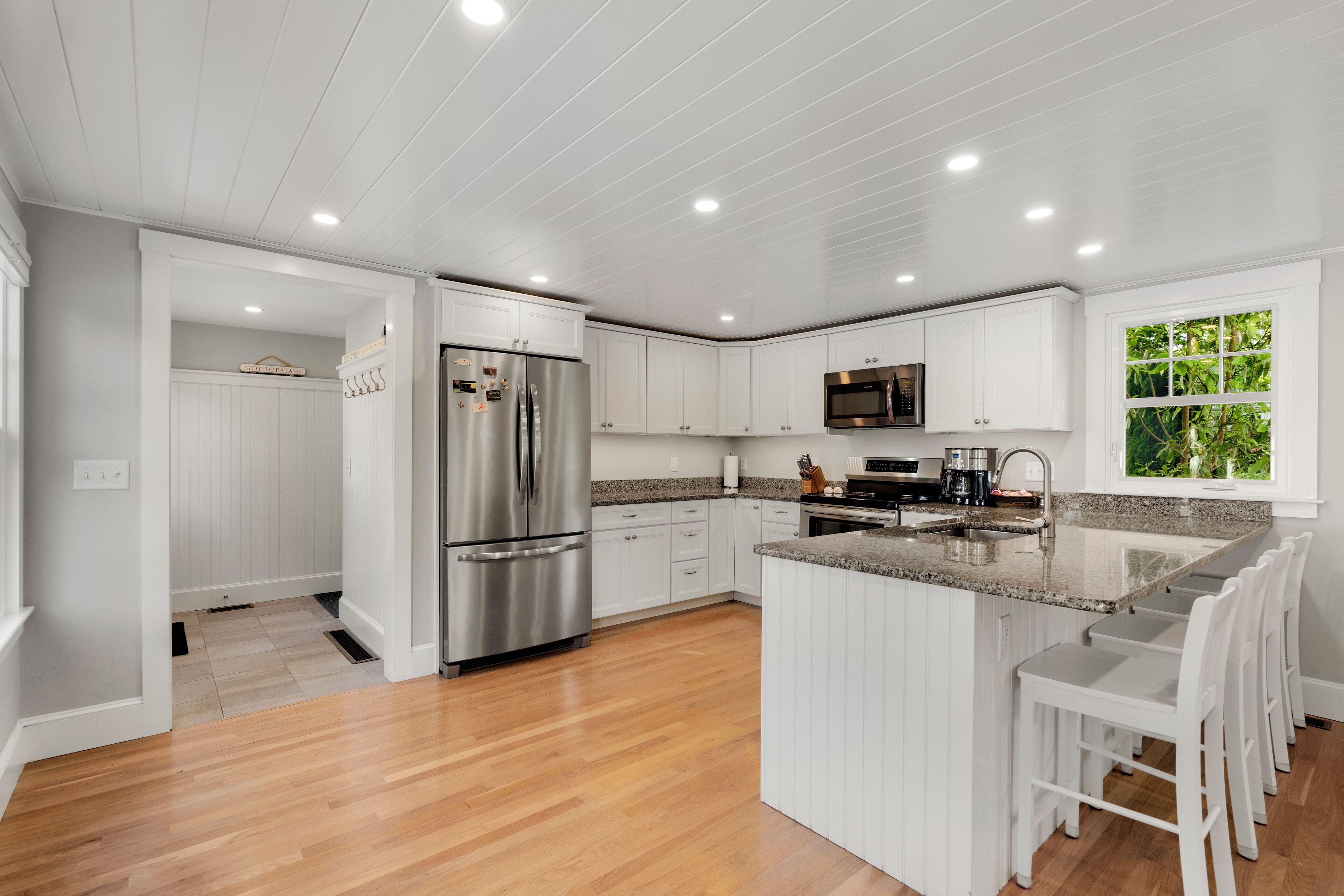 A modern kitchen with white cabinetry, stainless steel appliances, and a granite countertop.