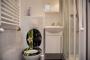 A bathroom with a toilet, sink, and shower.