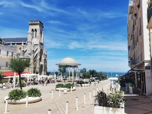 A plaza with a historic building, a gazebo, and a café.