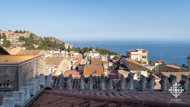 A coastal town with terracotta rooftops, historic buildings, and a view of the sea. - Casa Majorana - Vista mare (Taormina)