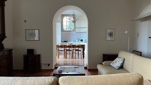 Ein Wohnzimmer mit einer Couch, einem Couchtisch und einem Essbereich mit einer Kronleuchter.
