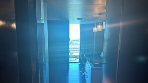 A hallway with a view of a building outside, a chandelier, and a tiled floor. - 1220 square feet strip view with upgraded WiFi  (Las Vegas)