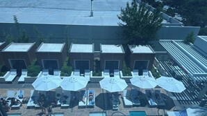 An outdoor swimming pool with lounge chairs and umbrellas, surrounded by a building with multiple rooms. - 1220 square feet strip view with upgraded WiFi  (Las Vegas)