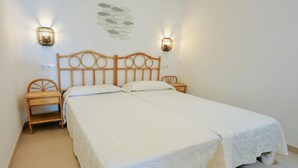 A double bed with a wooden headboard, two bedside tables, and wall-mounted lights. - Mundet 1 Baix Mar CostaBravaSi - Sea, beach and AC (Sant Antoni de Calonge)