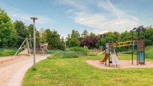 A playground with various play structures, a walking path, and surrounding greenery. - Nice apartment in Großenbrode OT Lütjenb with WiFi (Großenbrode OT Lütjenb)