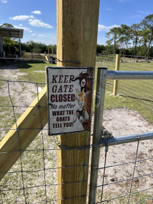 A wooden gate with a sign that reads "KEEP GATE CLOSED. No matter what the goats tell you!" - Luna’s Ranch - Little Lake House (Clewiston)