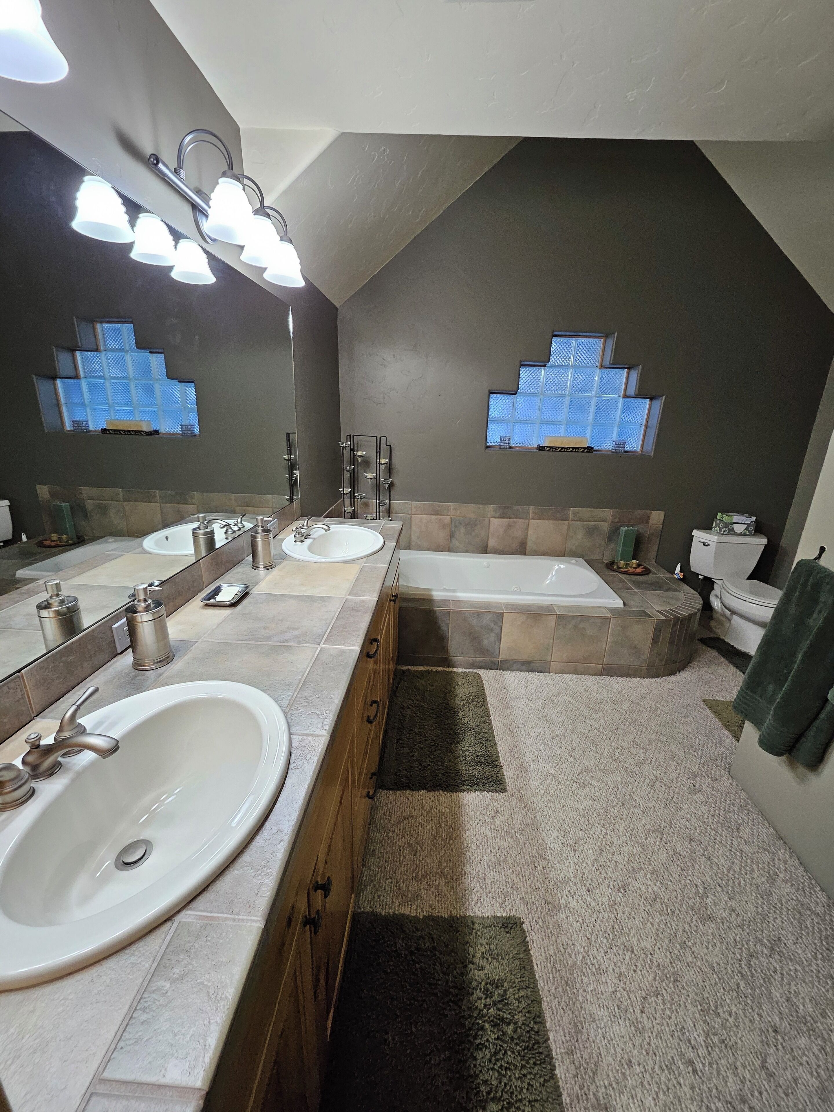 Une salle de bain moderne avec deux lavabos, une baignoire et des toilettes.