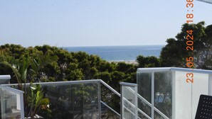 Une piscine d’un bleu éclatant, dotée d’un espace de détente, d’une structure entièrement vitrée et offrant une vue sur l’océan.
