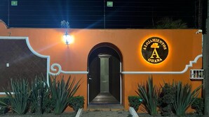 Un edificio con un letrero que dice "Alojamientos Ahona" y una entrada bien iluminada.
