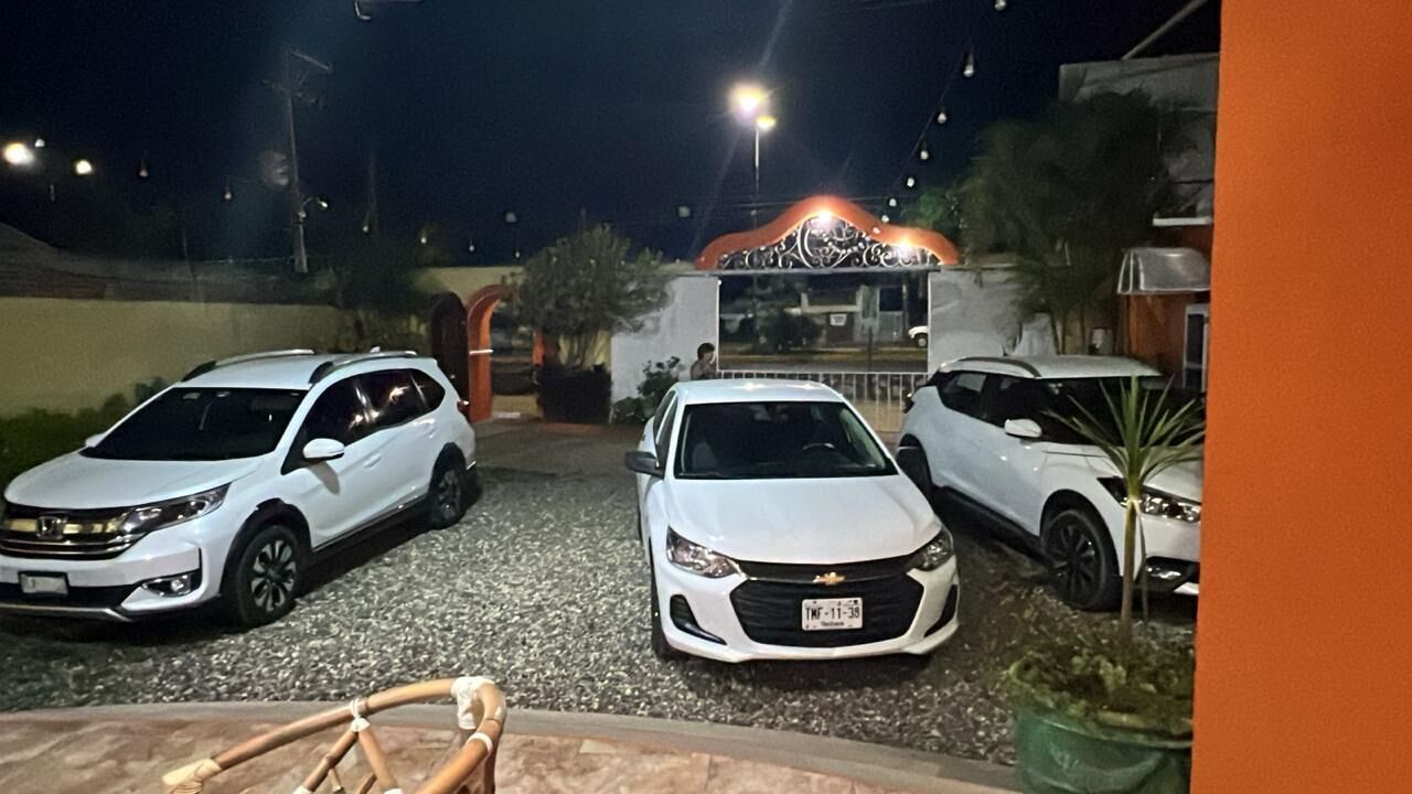 A parking area with three white Chevrolet SUVs parked.