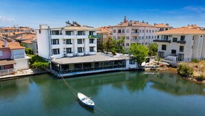 A hotel with a dock, a boat, and a river. - Olive Branch Hotel (Ayvalik)