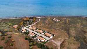 Luchtbeeld van een kustgebied met woonhuizen, een strand en een helder uitzicht op zee.