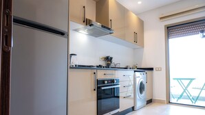 Une cuisine moderne équipée d’un four, d’un micro-ondes et d’un lave-linge intégrés.