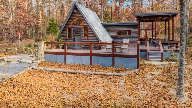 A cabin with a sloped roof, a porch, and a covered seating area. - Canyon A-Frame Cabin | Fire Pit, Sauna, Hiking (Fort Payne)