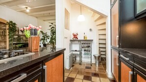 A modern kitchen with a checkered floor, a built-in oven, and a wine rack. - Lovely home in Sneek with WiFi (Sneek)