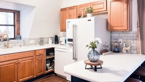A modern kitchen with wooden cabinets, a white refrigerator, and a marble countertop. - Cozy Wister Ridge A-Frame Lake Cabin • Sleeps 6 • Mins to Wister Lake! (Wister)