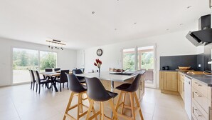 A modern kitchen with a central island, bar stools, and a dining area with chairs. - Beautiful home in Bezinghem with WiFi (Bezinghem)