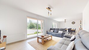 A modern living room with a grey sofa, a wooden coffee table, and a dining area with a table and chairs. - Beautiful home in Bezinghem with WiFi (Bezinghem)