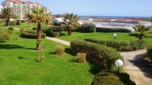 Un hotel con un jardín cuidado, vistas despejadas al mar y una estructura de edificio moderna.