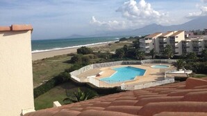 Un resort con piscina, vistas a la playa y varias edificaciones.