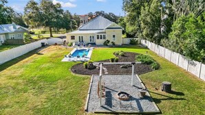 A backyard with a swimming pool, a fire pit, and a deck. - Quiet Historic Family Retreat with Pool--Pet Friendly--No Events (Bushnell)